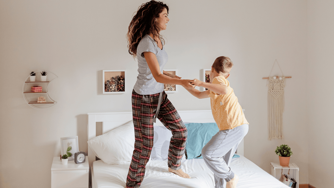 woman and boy jumping on a mattress