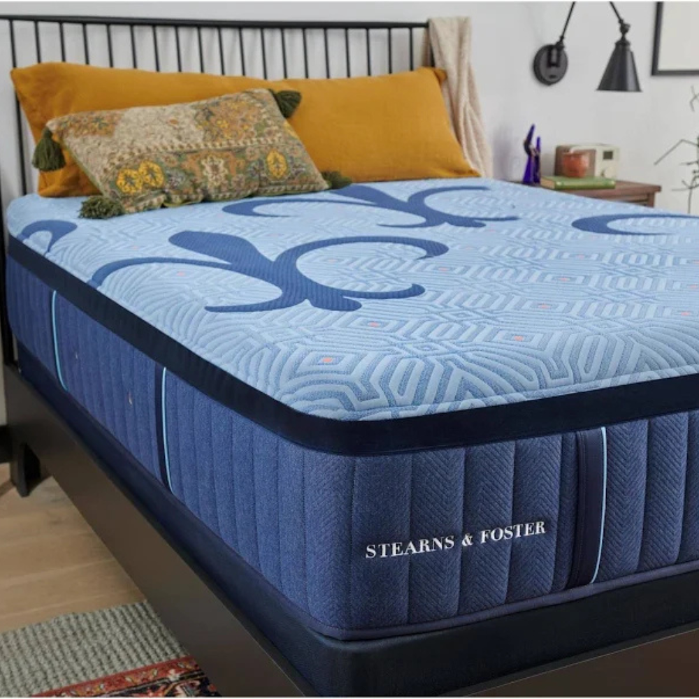 Blue Penley mattress with Stearns & Foster logo on a bed in a room setting.