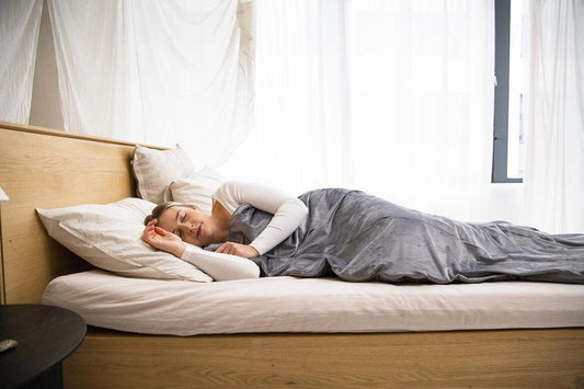 A woman lying on a bed peacefully.