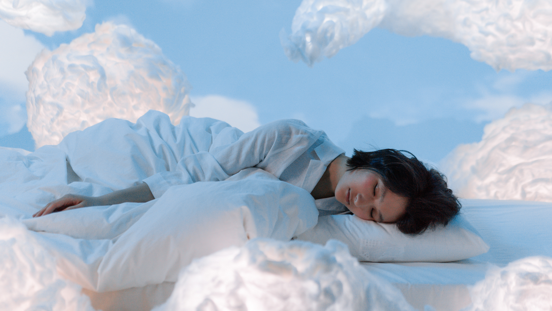 woman sleeping in on her side in blue pajamas, sleeping in the clouds