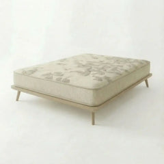 Natura Eco Haven mattress featuring a subtle leaf pattern and a light wood frame with tapered legs, set against a plain off-white background.