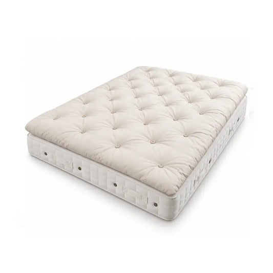 Alpaca wool tufted mattress topper with Hypnos Sherbourne mattress shown at an angle on a clean white background. The top surface features a diamond tufted pattern in a warm cream/off-white color, while the side bolster is white with small metal grommets.