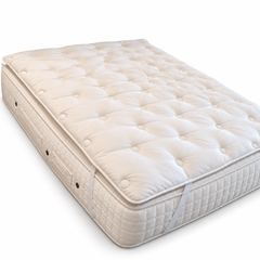 Hypnos Wool Silk Cotton mattress topper shown at an angle on a mattress.