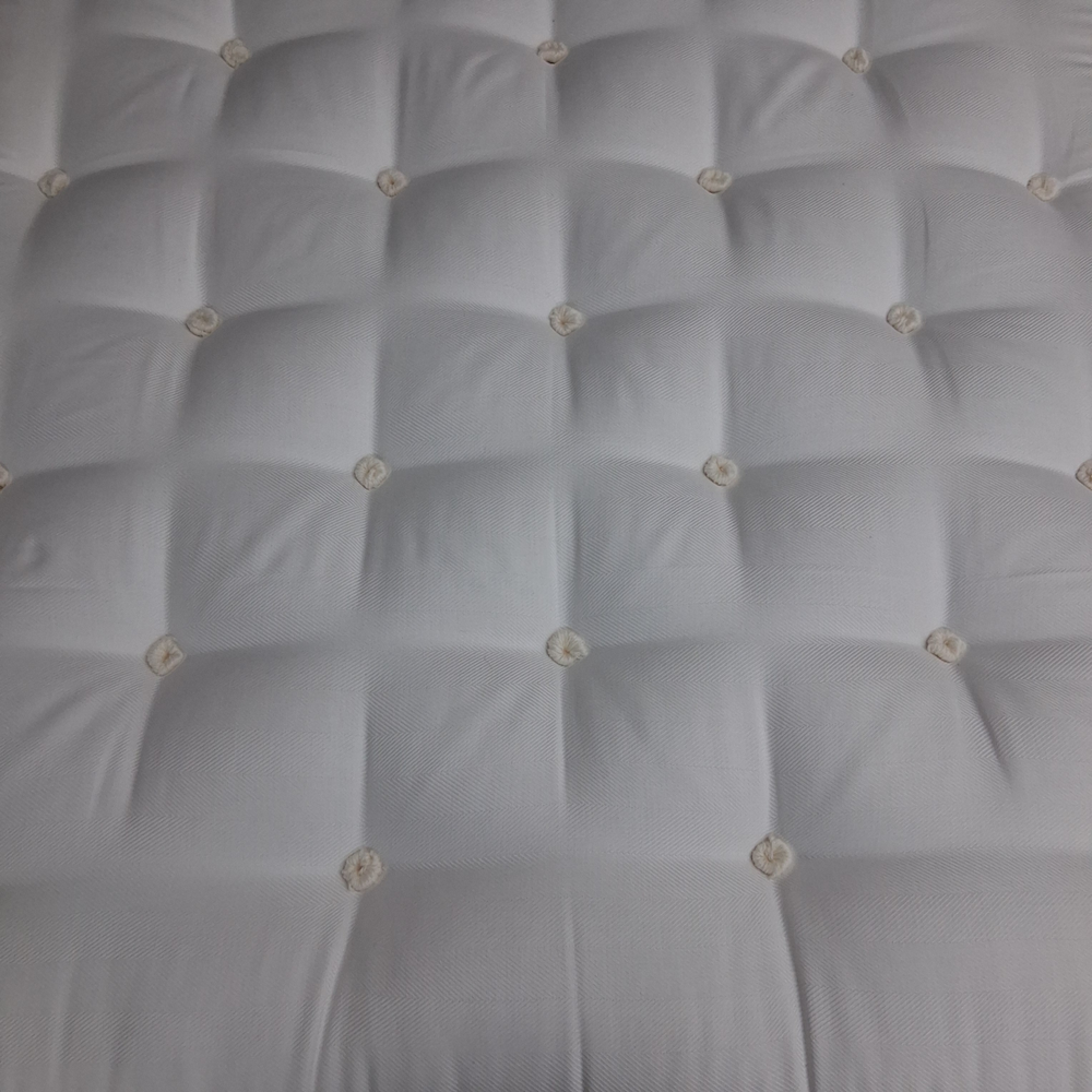 White tufted Sprout Mattress Top made of cotton.