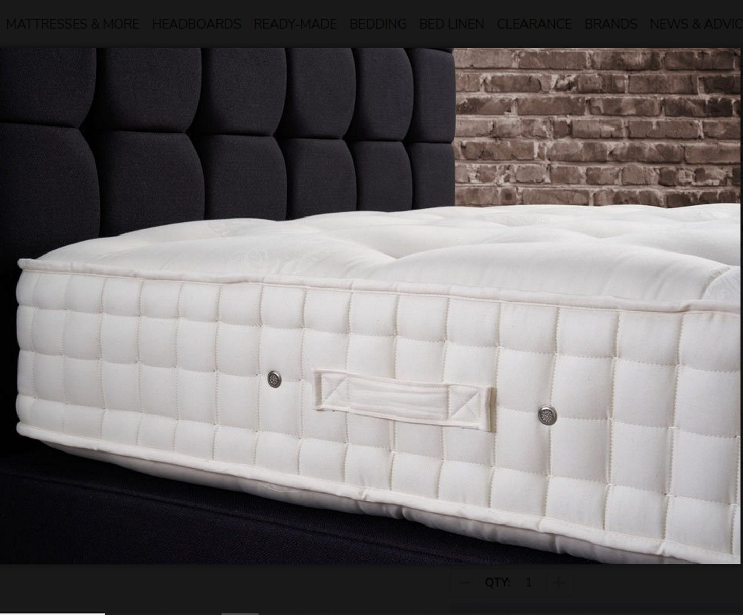 A close-up of Hypnos Viceroy mattress side panel, shown resting on a dark upholstered bed frame against a black tufted headboard and brick wall background.
