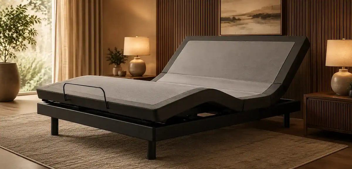 An adjustable electric bed frame with a gray mattress shown in a styled bedroom setting with warm wood paneling, bedside tables, lamps, and a rug.-image